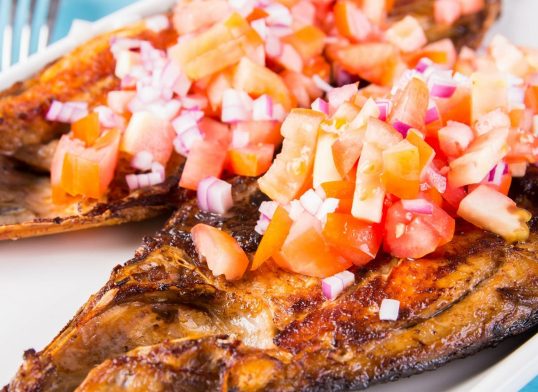 fried bangus or milkfish topped with fresh sliced onions and tomatoes