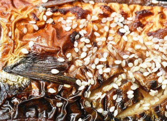 grilled Saba fish or mackerel with sweet black soy sauce topping white sesame on plate