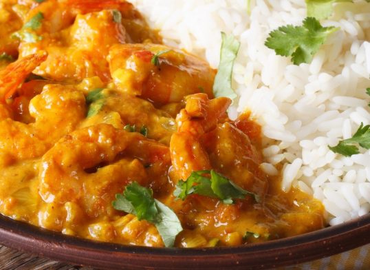 Shrimps in curry sauce with rice and cilantro horizontal