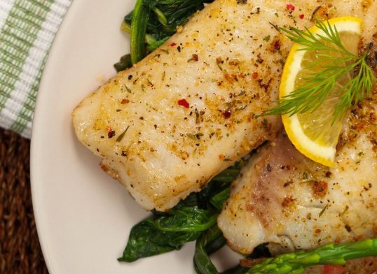 Baked Fish Fillet with Sauteed Spinach. Selective focus.
