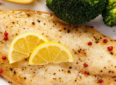Fried fish fillet with broccoli on white background