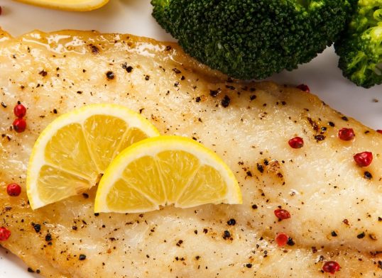 Fried fish fillet with broccoli on white background