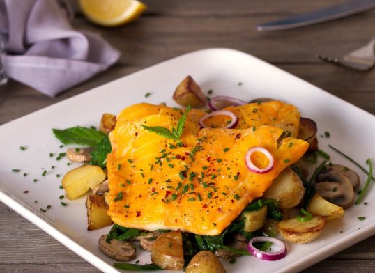 Smoked cod fish fillets with potatoes, mushrooms and spinach
