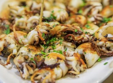 Traditional Italian street food in Venice - fried baby calamari on display on a plate at a stall