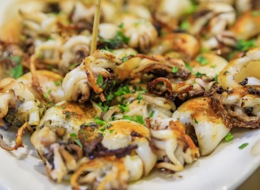 Traditional Italian street food in Venice - fried baby calamari on display on a plate at a stall
