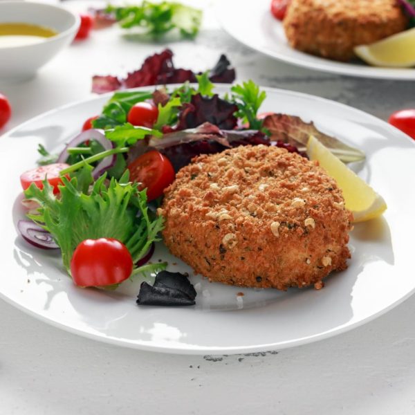 Home made Fish Cake salmon, spinach and potato. served on plate with vegetables