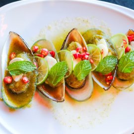 Plate of half shell mussels with garnish